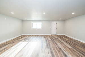 Basement with wood finished floors, recessed lighting, and baseboards and separate walk out to back yard.