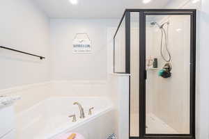 Bathroom with recessed lighting, a marble finish shower, and a bath