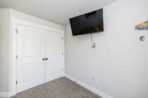 Unfurnished bedroom featuring carpet, a closet, and baseboards