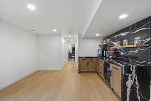 Bar featuring light wood-style flooring, beverage cooler, visible vents, a bar, and recessed lighting