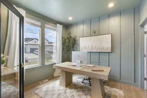 Office space featuring visible vents, wood finished floors, and plenty of natural light