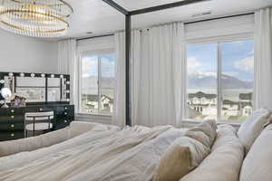 Bedroom featuring a mountain view, a chandelier, visible vents, and a textured ceiling