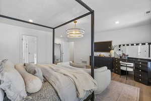 Bedroom featuring a notable chandelier, a textured ceiling, visible vents, and wood finished floors