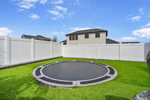 View of yard with a fenced backyard and a trampoline