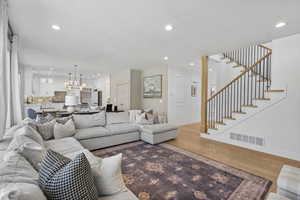 Living area with recessed lighting, visible vents, baseboards, and light wood-type flooring