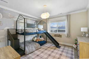 Bedroom featuring crown molding, visible vents, wood finished floors, and baseboards