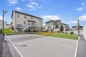 View of sport court with a residential view, a yard, playground community, community basketball court, and fence