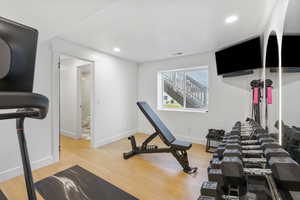 Exercise area featuring baseboards, visible vents, wood finished floors, and recessed lighting