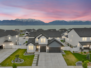Traditional-style house featuring concrete driveway, a front yard, a mountain view, an attached garage, and fence