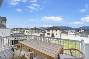 Wooden deck with a fenced backyard, a mountain view, a residential view, and outdoor dining area