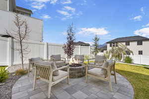 View of patio with a fire pit and fence