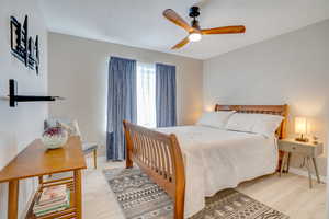 Bedroom featuring light wood-style flooring, ceiling fan, and baseboards