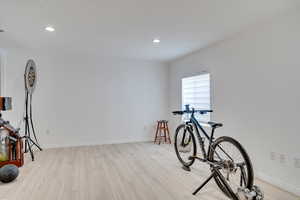 Exercise room featuring light wood-style floors, recessed lighting, and baseboards