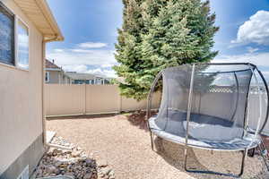 Fenced backyard with a trampoline