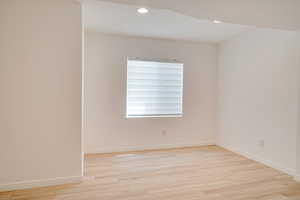 Unfurnished room with light wood-style flooring, recessed lighting, and baseboards