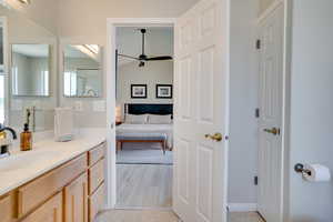 Ensuite bathroom featuring vanity, a ceiling fan, and tile patterned floors