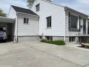 View of property exterior featuring driveway and a carport