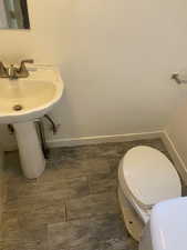 Half bathroom featuring toilet and baseboards