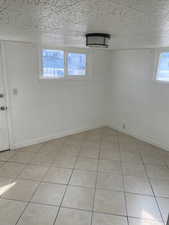 Unfurnished room featuring baseboards and light tile patterned floors