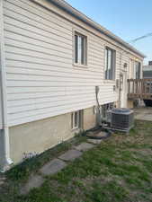 View of side of home with central AC and a deck
