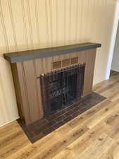 Interior details featuring a fireplace, wood finished floors, and visible vents