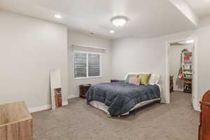 Bedroom with a spacious closet, recessed lighting, baseboards, and carpet floors