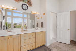 Bathroom with tile patterned floors, a stall shower, a towering ceiling, and a sink