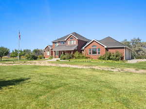 View of front of home featuring a front yard, brick siding, a porch, concrete driveway, and a garage