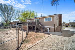 View of front of property featuring a gate, stairs, a chimney, a deck, and fence