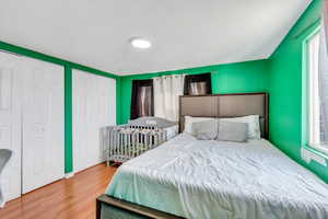 Bedroom with a textured ceiling and wood finished floors