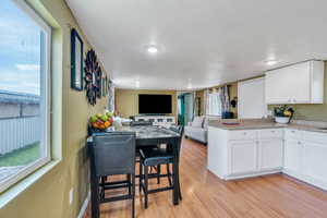 Kitchen featuring plenty of natural light, light wood-style flooring, and white cabinets