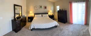 Bedroom featuring light carpet and lofted ceiling