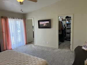 Bedroom featuring a textured ceiling, carpet flooring, a closet, baseboards, and a walk in closet