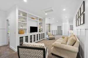 Carpeted living area featuring attic access, visible vents, recessed lighting, and baseboards