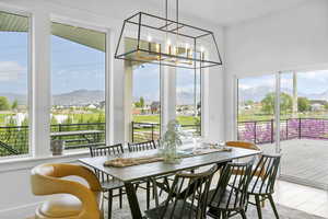 Interior space featuring wood finished floors, a chandelier, a healthy amount of sunlight, and a mountain view