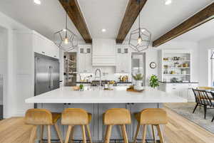 Kitchen featuring white cabinetry, open shelves, light wood-style flooring, and decorative backsplash