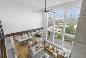 Living room featuring a high ceiling, recessed lighting, a ceiling fan, and hardwood / wood-style flooring