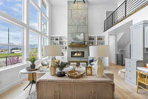 Living room featuring baseboards, light wood-style flooring, and a towering ceiling
