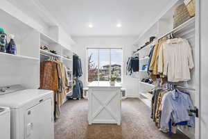 Spacious closet featuring independent washer and dryer and light carpet
