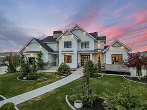 View of front of house featuring stone siding, a standing seam roof, metal roof, a chimney, and a front yard