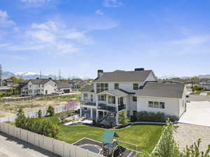 Back of property with a mountain view, a fenced backyard, a residential view, and stucco siding