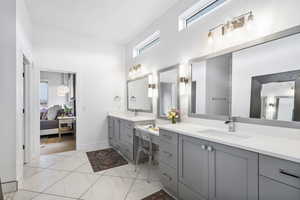 Full bathroom featuring a high ceiling, ensuite bath, marble finish floor, and a sink
