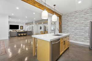Kitchen with recessed lighting, stainless steel dishwasher, a kitchen island with sink, finished concrete flooring, and a sink