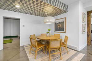 Dining space with concrete floors, visible vents, and baseboards
