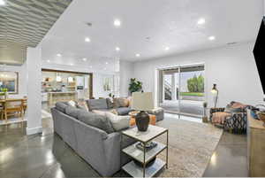 Living area featuring recessed lighting, a healthy amount of sunlight, and finished concrete flooring