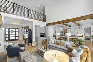 Living area with a high ceiling, a barn door, light wood-style floors, and recessed lighting