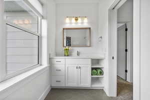 Bathroom with tile patterned floors, vanity, and baseboards