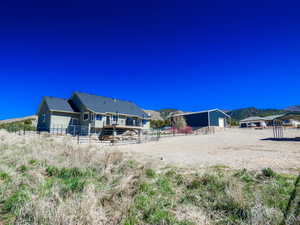 View of yard with an outbuilding, a mountain view, and fence