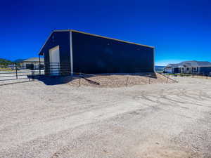 View of outbuilding featuring fence and an outbuilding