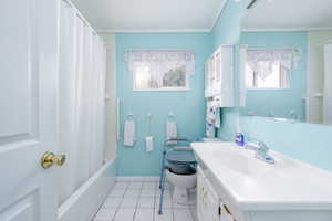Full bath featuring vanity, tile patterned floors, toilet, baseboards, and ornamental molding